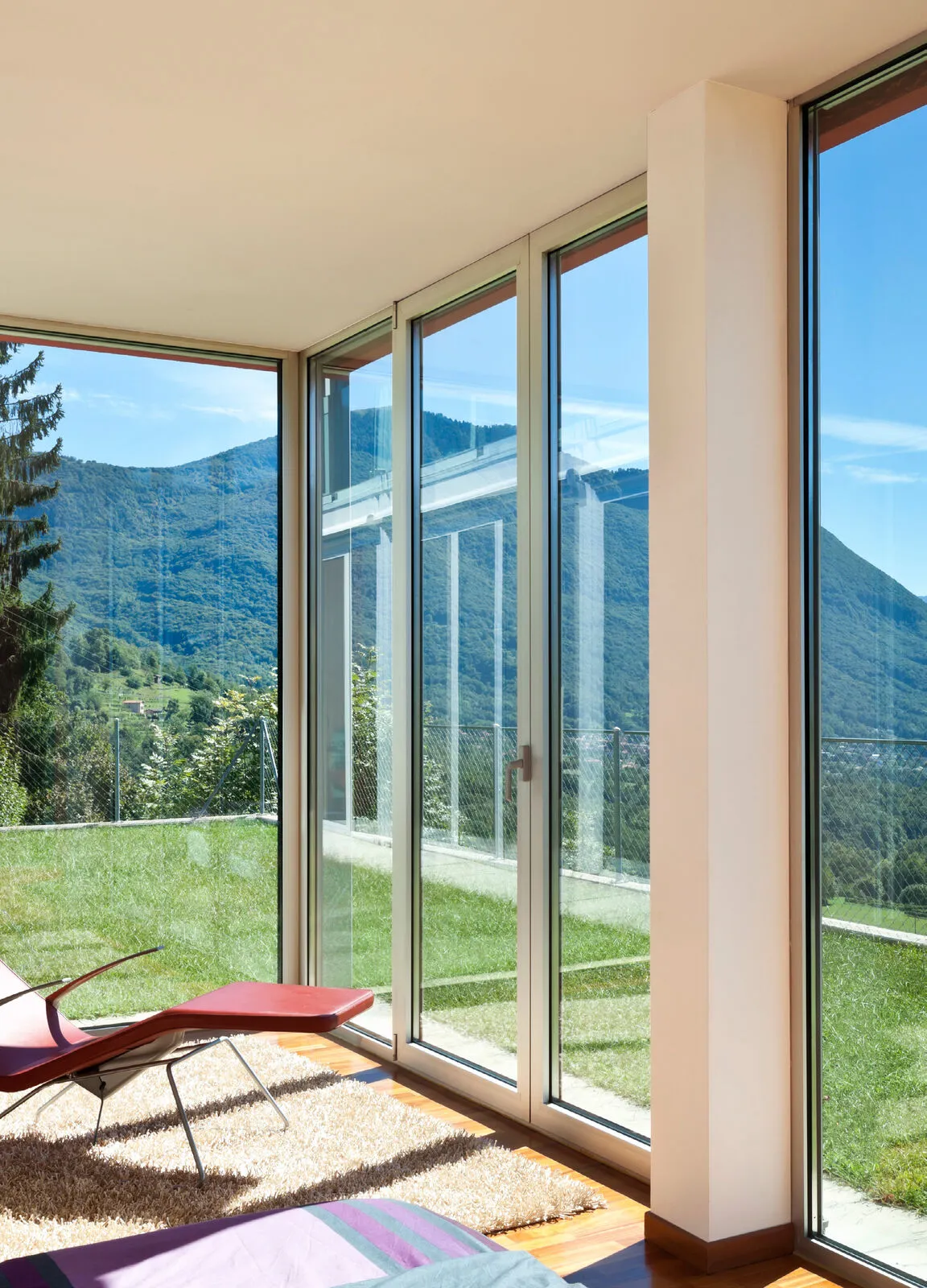 Floor-to-ceiling glazing opening a living space to a mountain view