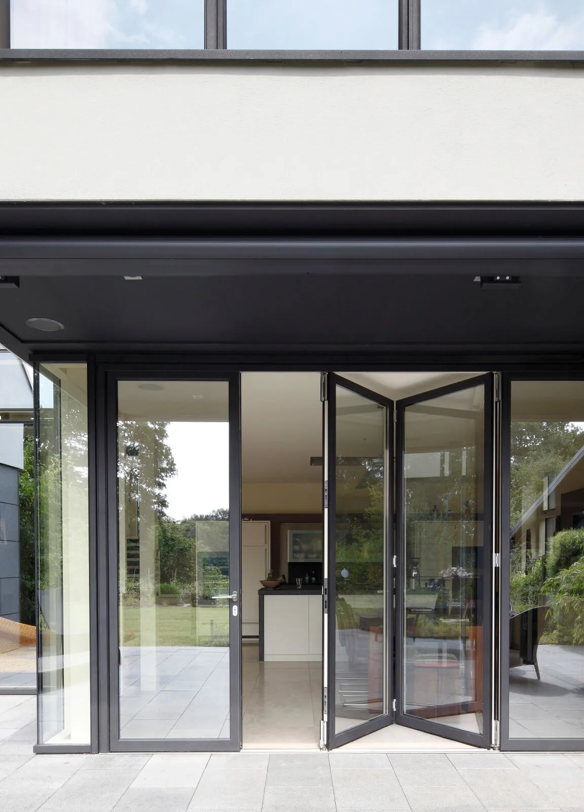 Black-framed bi-fold door partially opened in a modern kitchen